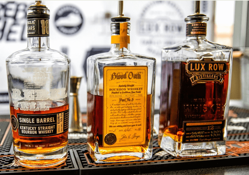 Three bottles of Kentucky bourbon whiskey displayed on a bar counter