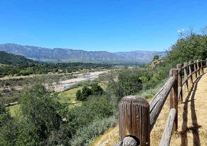 Wooden fence overlooking mountains and river along Ventura to Ojai bike trail.